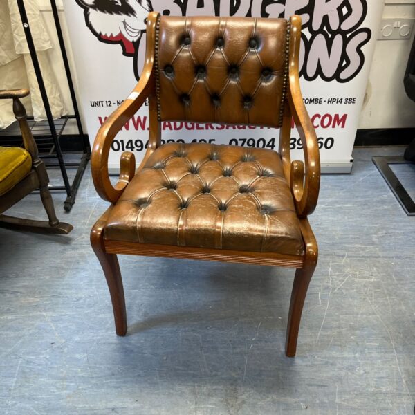 Brown leather Chesterfield chair with button tufting, vintage style.