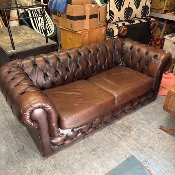 Brown leather chesterfield sofa, a vintage two-seater.