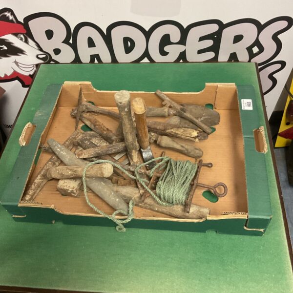 Assorted builders tools in a box, including chisels and screwdrivers.