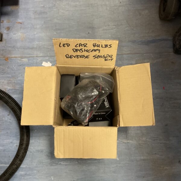 Car dashcam kit with LED bulbs and reverse sensor in original packaging.