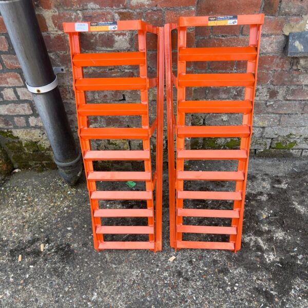 Orange steel car ramps for vehicle maintenance and repair.