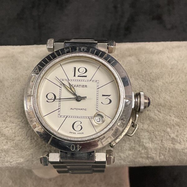 Close-up of the silver dial on a vintage Cartier automatic watch.