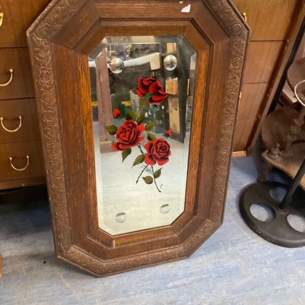 Antique carved rose mirror with detailed floral frame.