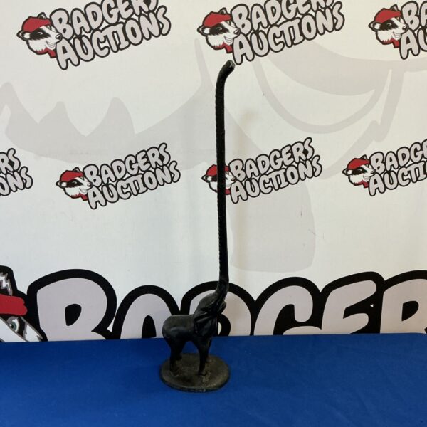 Antique cast iron elephant doorstop against patterned backdrop.