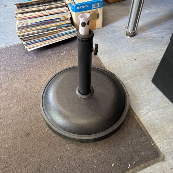 Dark cast iron parasol base for garden umbrellas.