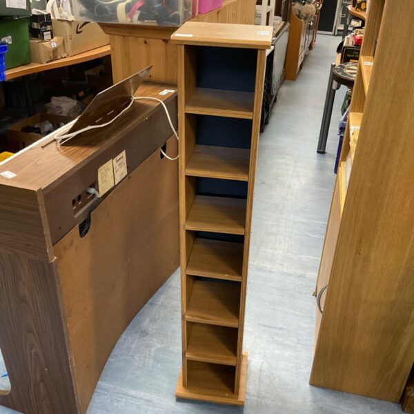 Tall wood effect CD storage unit with multiple shelves.