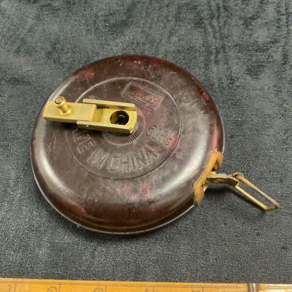 Vintage Chinese bakelite tape measure showing 50ft marking.