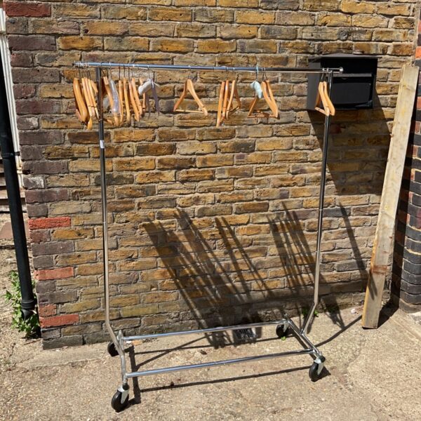Chrome clothes rail with hangers, offering portable garment storage.