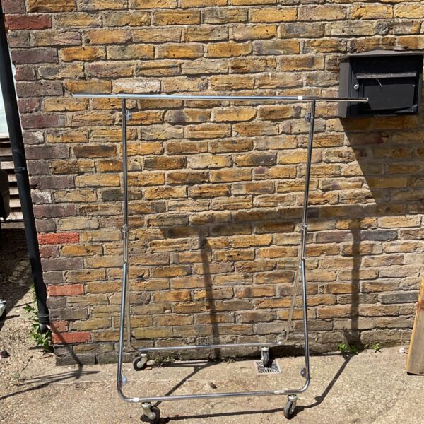Chrome folding clothes rail on wheels for garment storage.