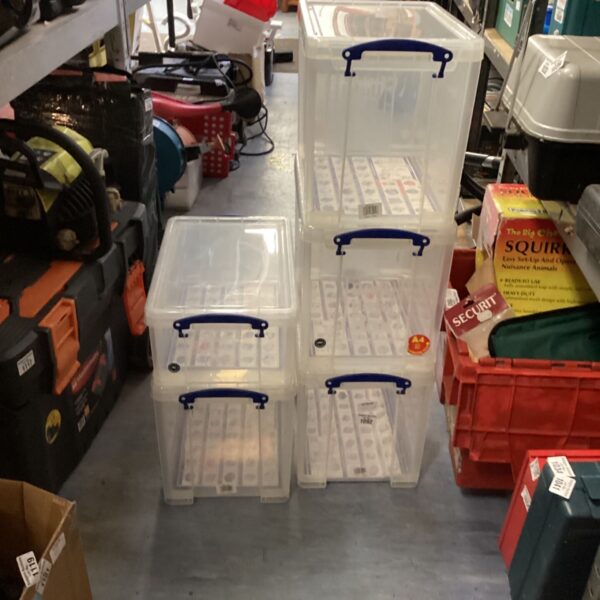 Lot of five clear plastic storage boxes for home organization.