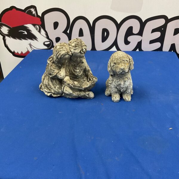 Small concrete garden statue of a seated dog.