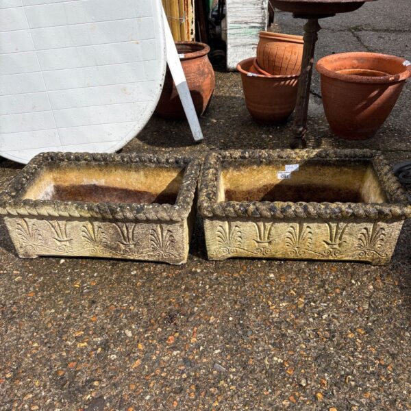 Pair of weathered concrete garden planters with leaf detailing.
