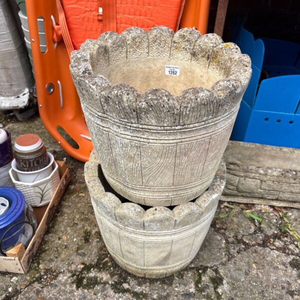Pair of grey concrete garden planters on display.