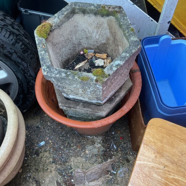 Weathered concrete planter in terracotta pot for garden display.