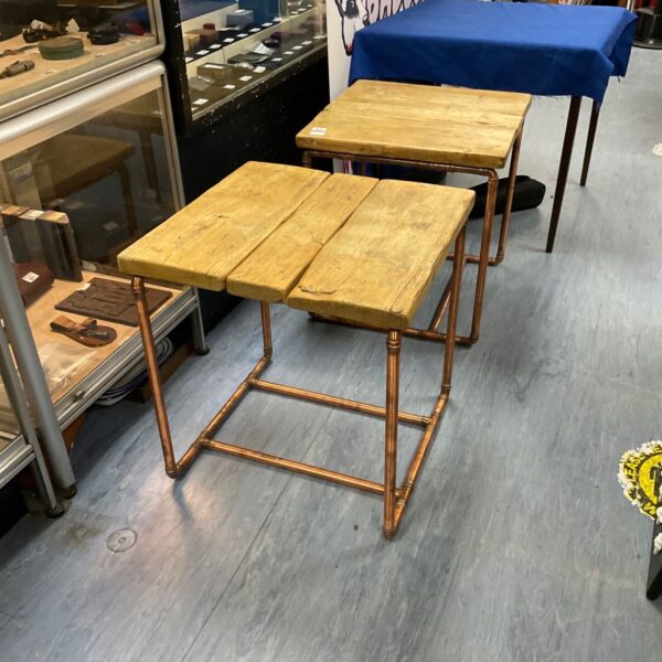 Rustic copper pipe side tables with wood tops.