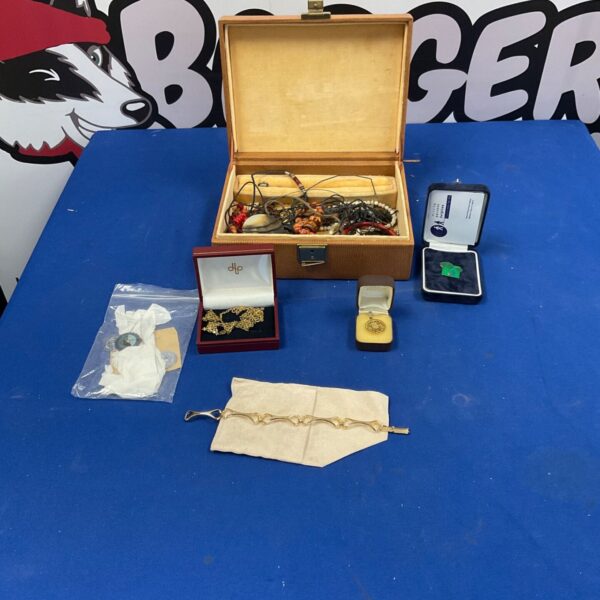 Open jewellery box filled with vintage costume jewellery and necklaces.