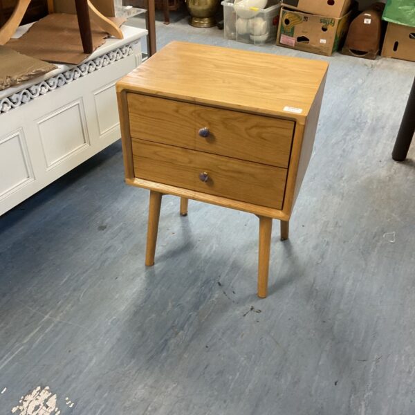 Light wood bedside cabinet with two drawers and tapered legs.