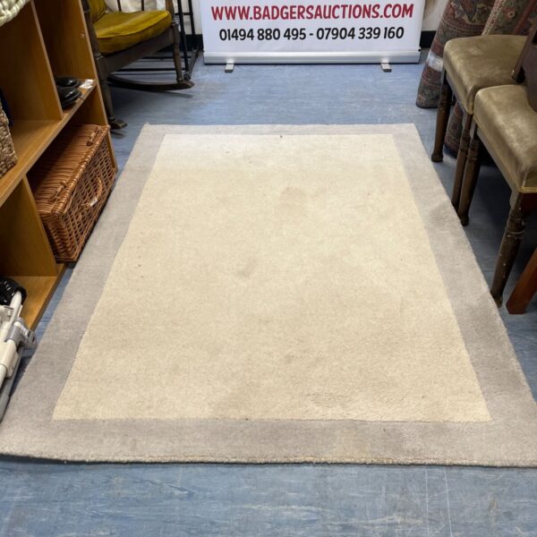 Cream Berber rug with a deep pile and classic design.