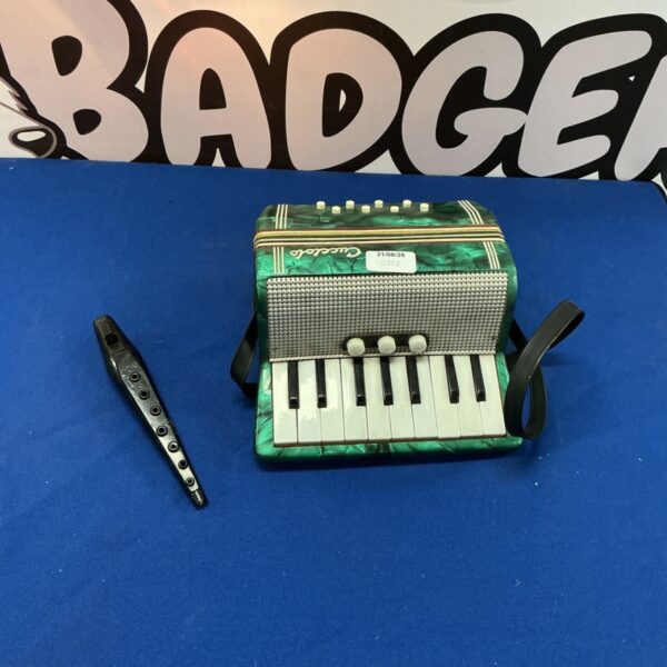 Vintage green Cucciolo accordion, a children’s musical instrument.