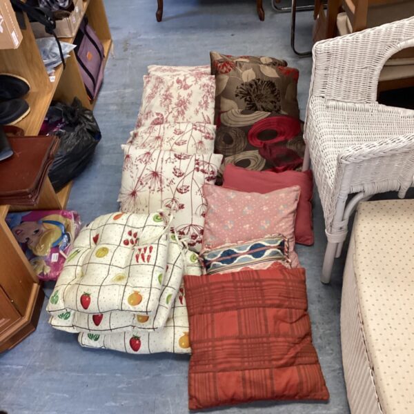 Job lot of patterned cushions including floral and geometric designs.