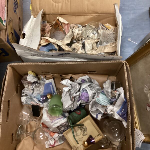 Two boxes filled with colourful decorative glassware for collectors.