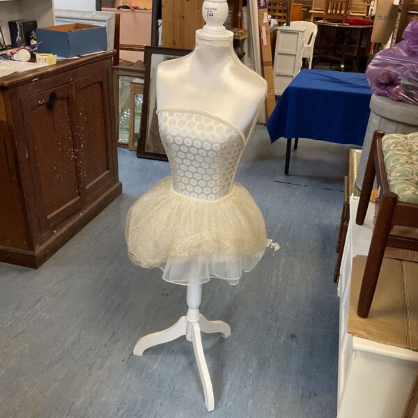 Gold decorative mannequin on tripod stand for display.