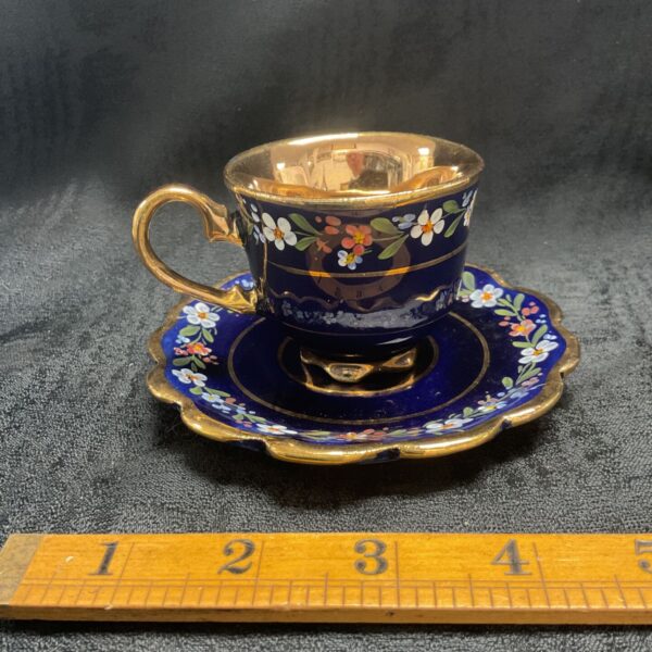 Antique cobalt blue demitasse cup and saucer with floral details.