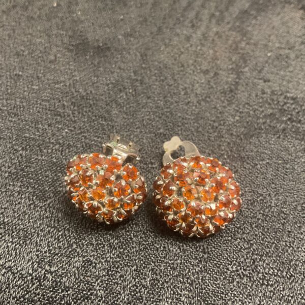 Vintage Dior clip-on earrings with orange rhinestones, front view.