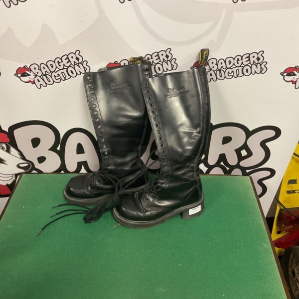 Black leather Dr Martens boots with laces, showing wear.