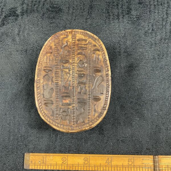 Large Egyptian scarab beetle with detailed hieroglyphic carvings.