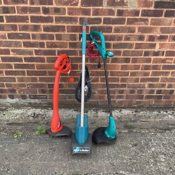 Lot of three electric garden strimmers for lawn and garden maintenance.