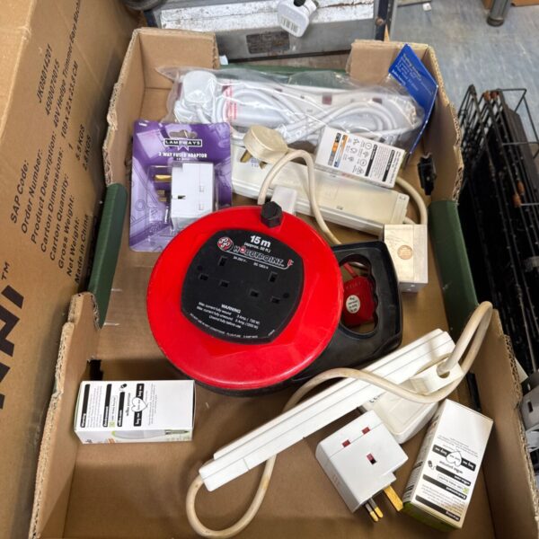 Tray of assorted electrical extension leads and power accessories.