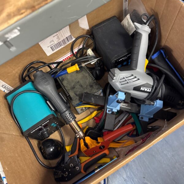 Assorted electronics repair tools including soldering iron and heat gun.