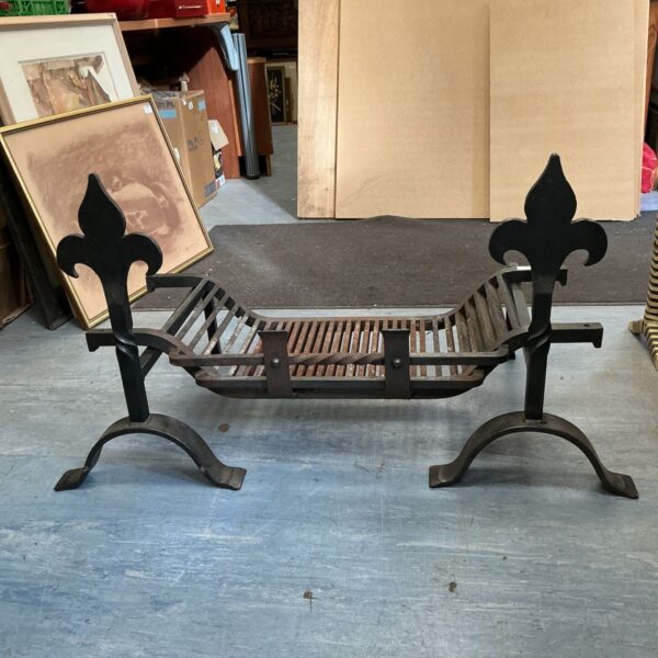 Antique wrought iron fireplace grate with Fleur-de-lis design.