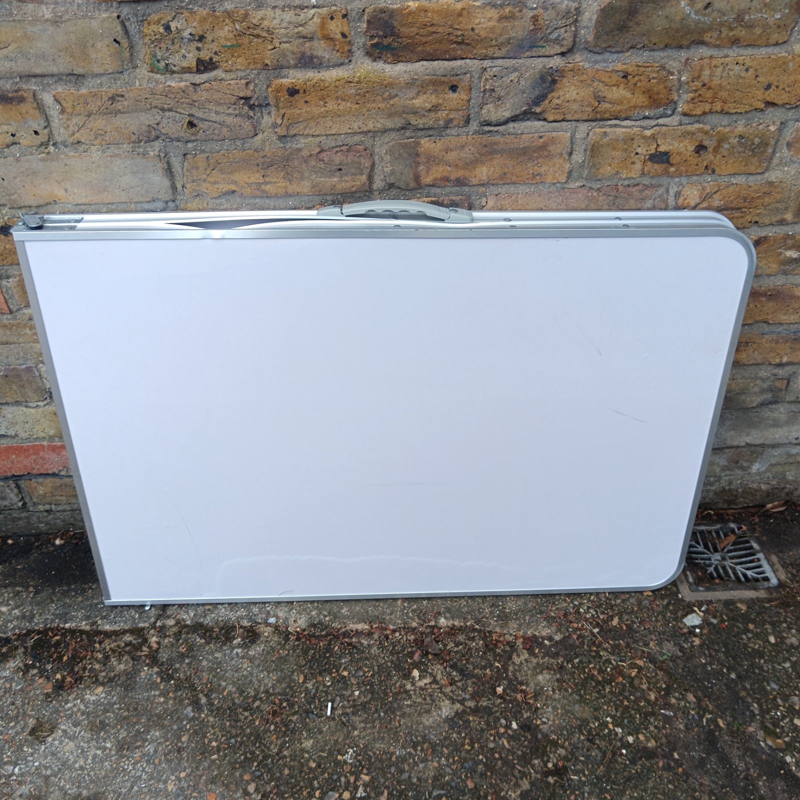 Aluminium folding camping table with a slight bend.