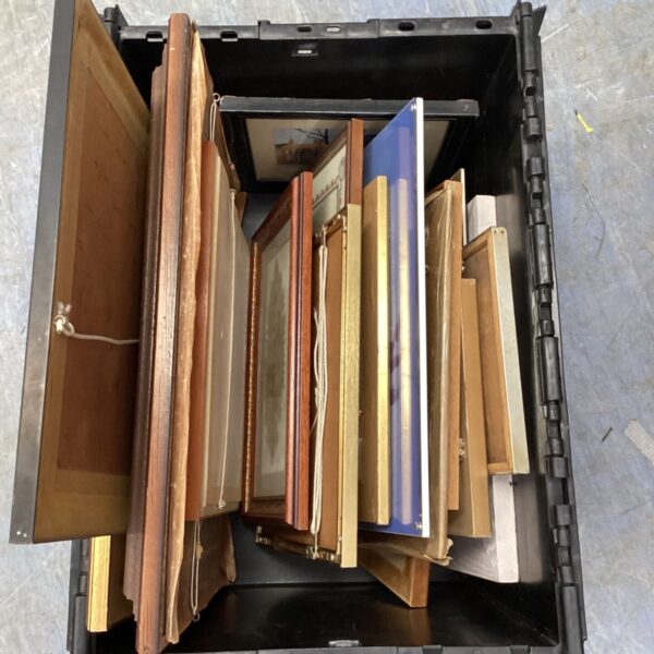 Assortment of framed artwork in a plastic storage box.