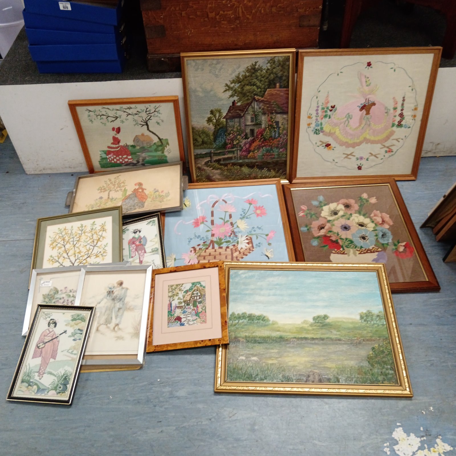 Large collection of vintage framed embroideries for wall decor.