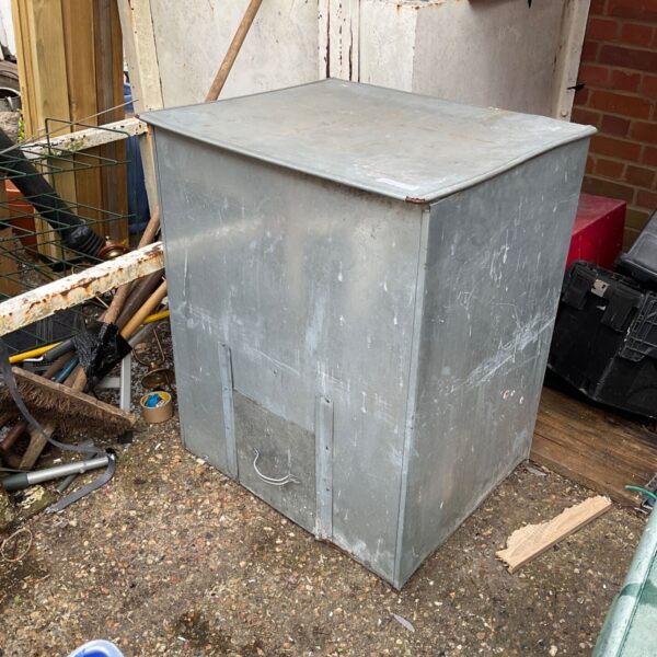 Vintage galvanised coal bunker for outdoor fuel storage.