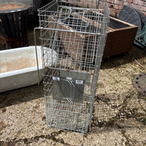 Vintage galvanized metal cage trap for animal control.