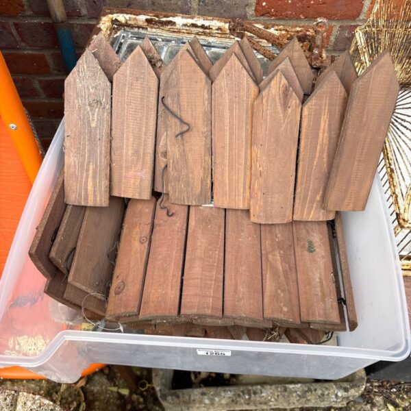 Wooden garden border edging pieces in a plastic container.
