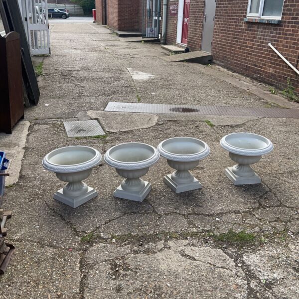 Set of four plastic garden planters in an outdoor setting.