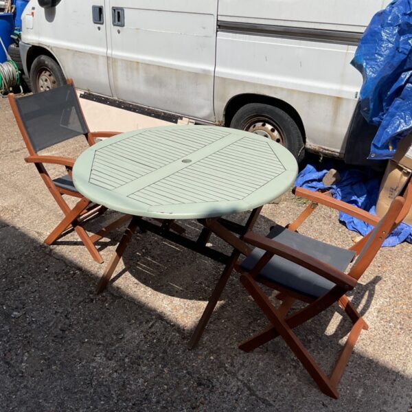 Vintage garden table and two chairs set in a garden.
