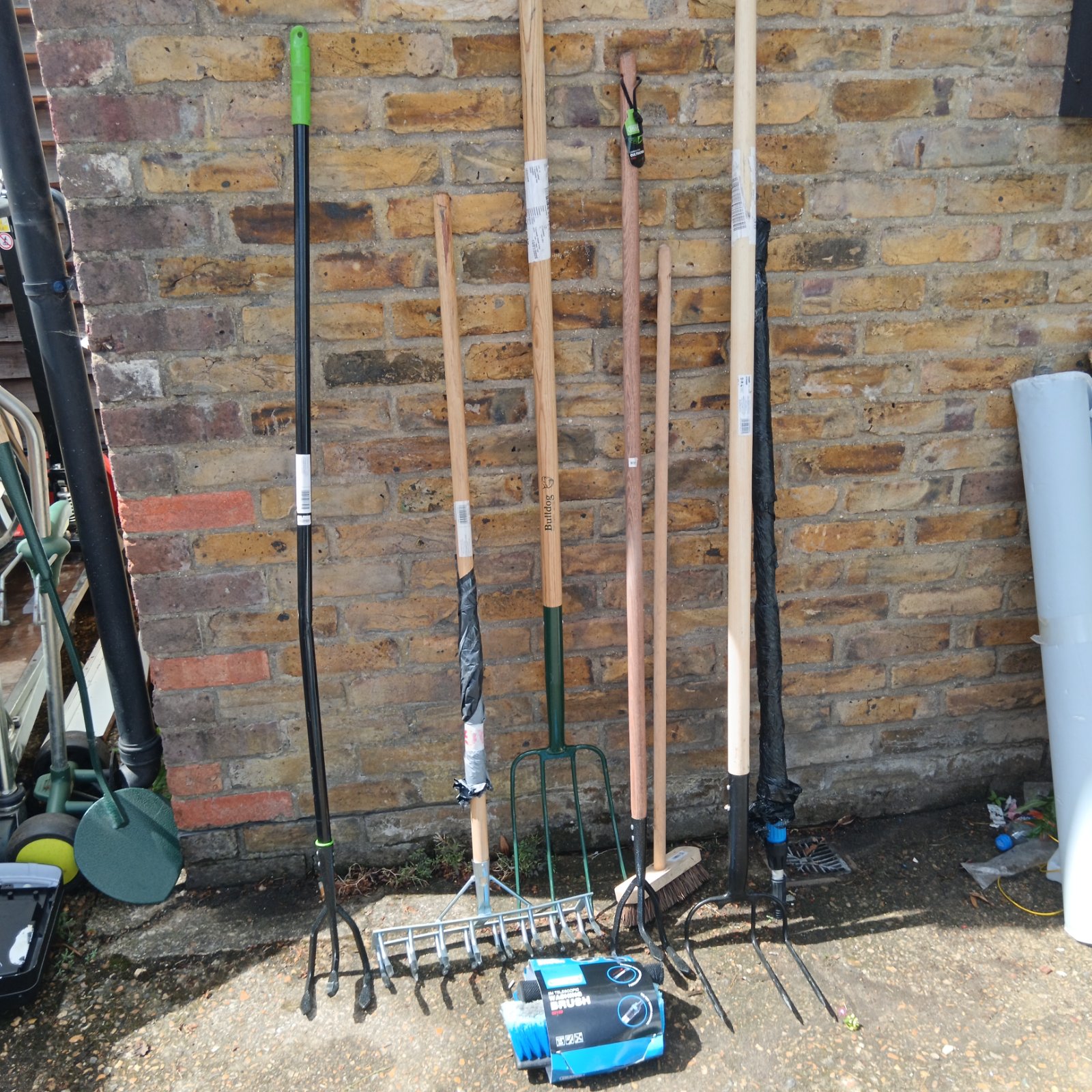 Garden tool bundle featuring a rake and cultivator with wooden handles.