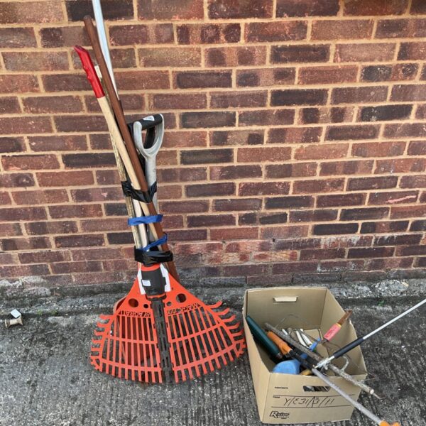 Garden tool lot featuring a shovel and orange brush.