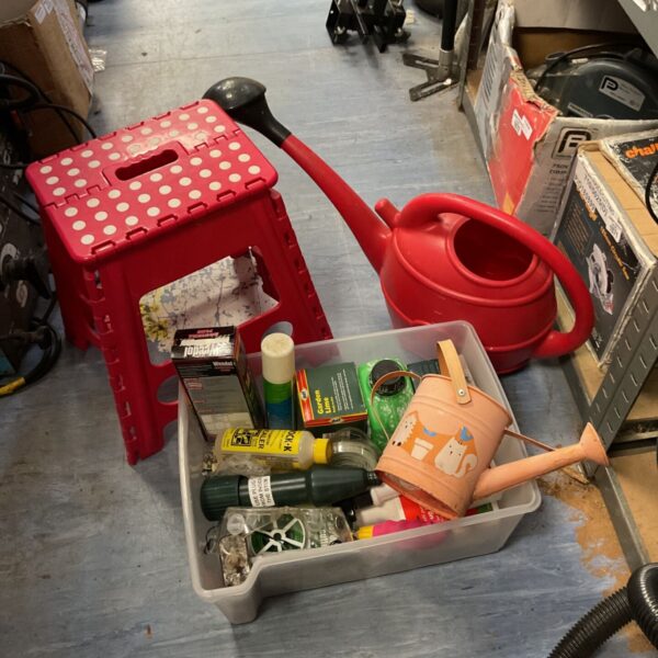 Gardening tool lot with red folding stool and watering cans.