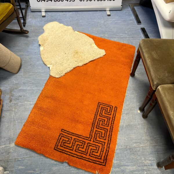 Burnt orange geometric rug with Greek key border.