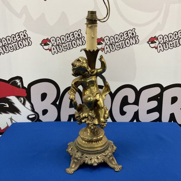 Antique gilded brass cherub table lamp base with intricate detailing.