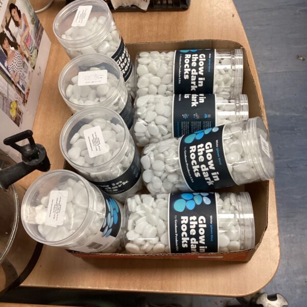 Tray of eight tubs filled with glow in the dark rocks.