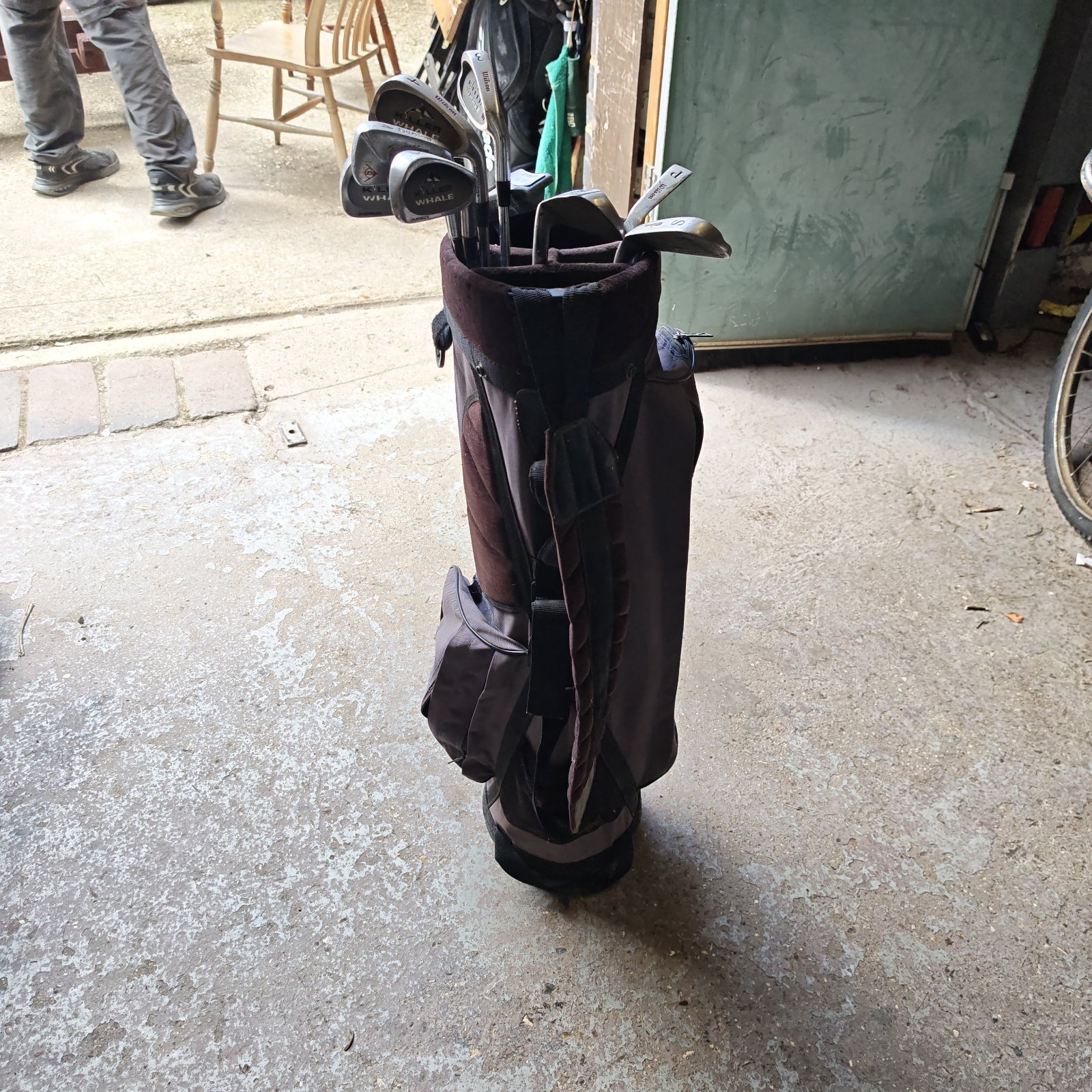 Vintage Wilson golf bag with clubs, showing signs of wear.