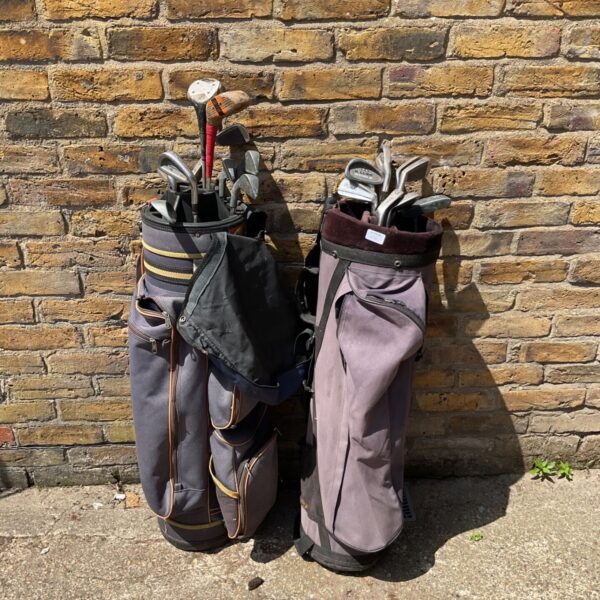 Vintage golf clubs with Wilson and Killer Whale branding in bags.